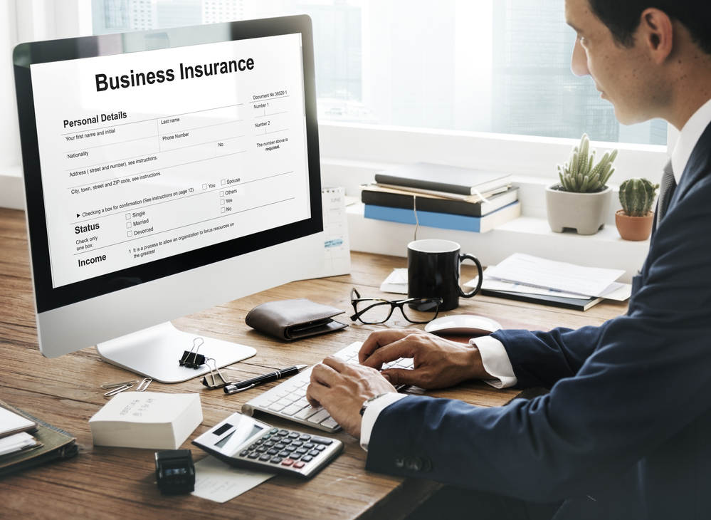 Man in suit demonstrating how to get business insurance on a computer